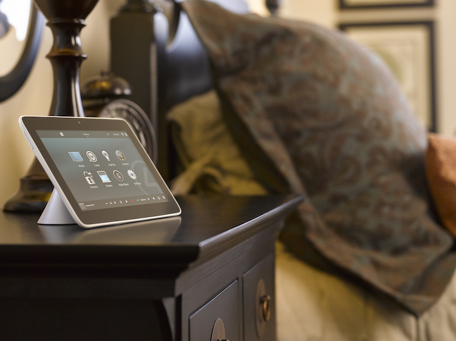 A Control4 system touchpad on someone’s bedside table.